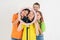 Â  Three teen girls and a boy smiling and shoots a video. Selfies. The phone is mounted on a tripod and the ring lamp shines